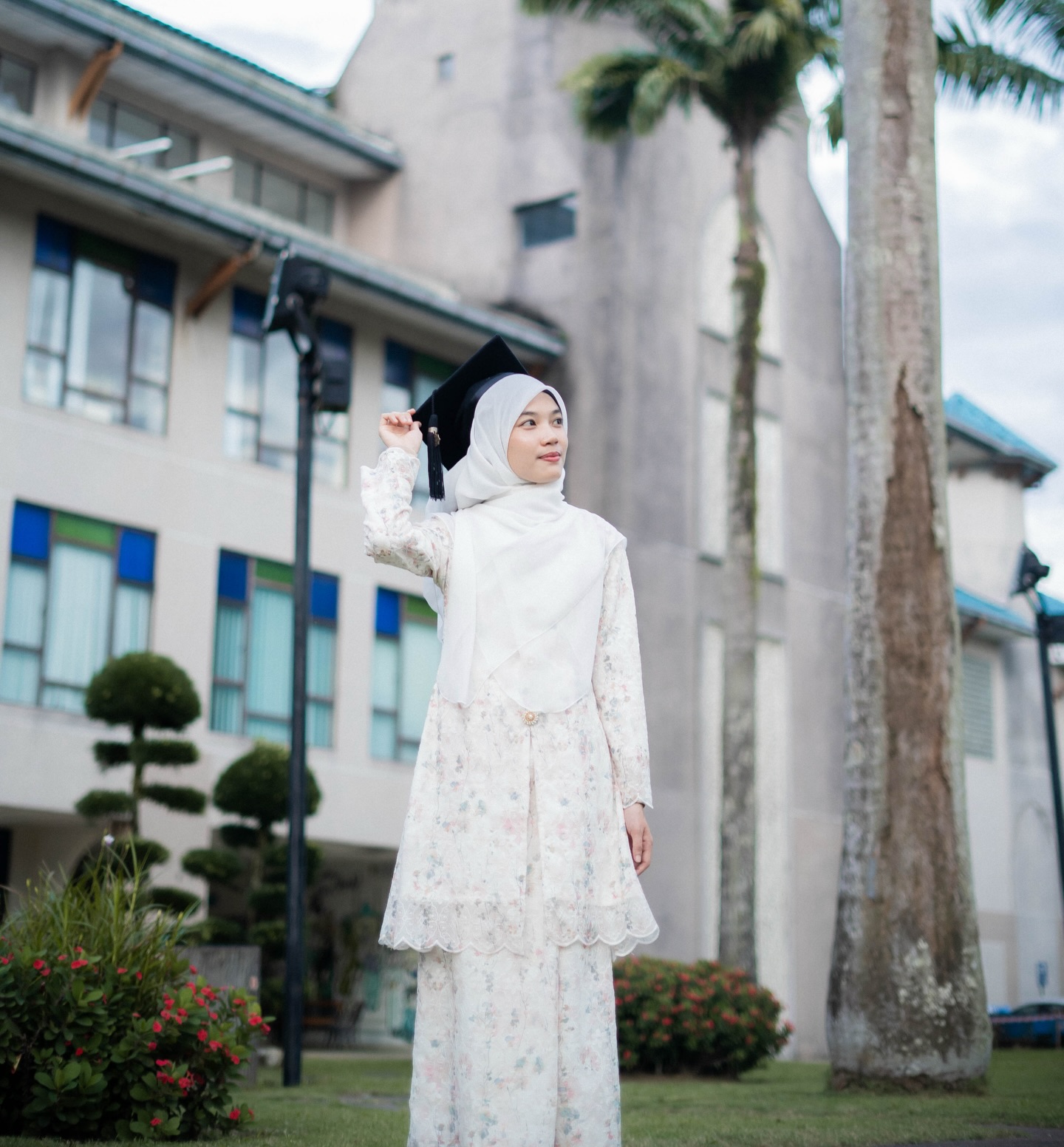 Afisah posing outdoors in her graduation cap