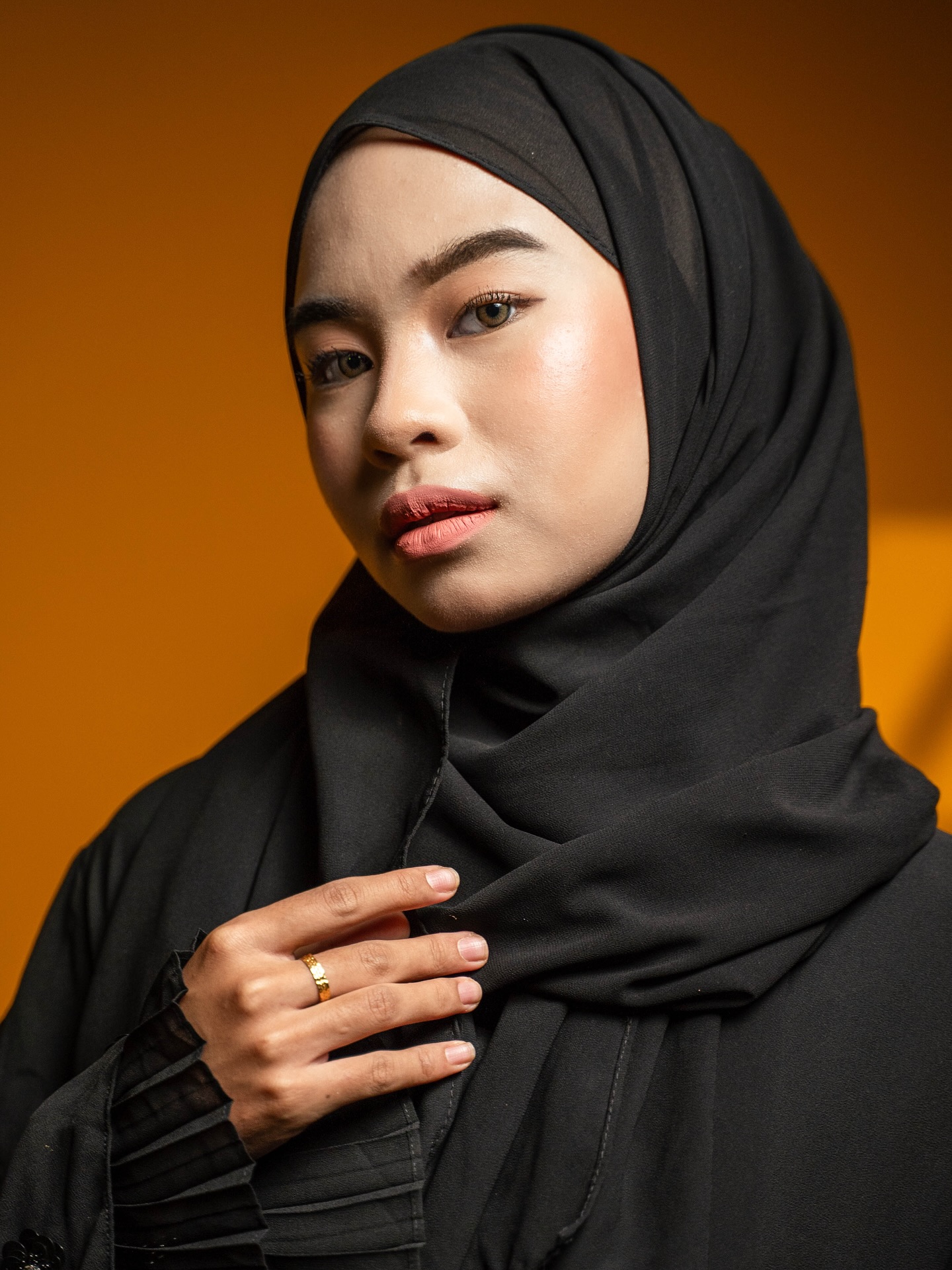 Studio portrait against a warm orange background